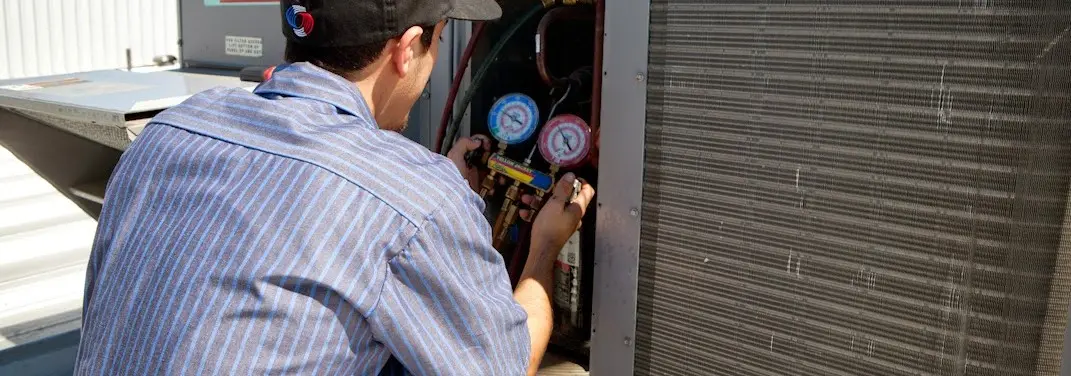 HVAC technician servicing a condenser unit in Isla Vista
