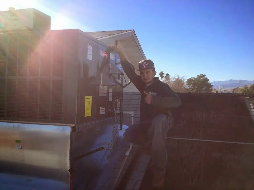 HVAC technician performing AC Tune-Up on a rooftop unit in Isla Vista